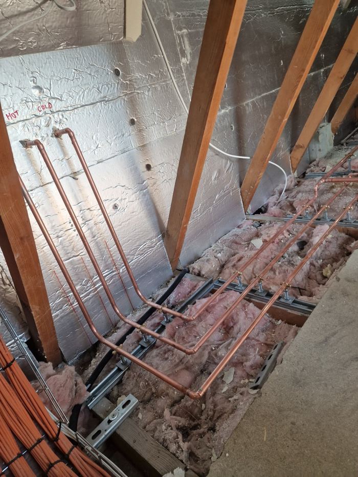 Neat runs of copper pipework laid between joists
